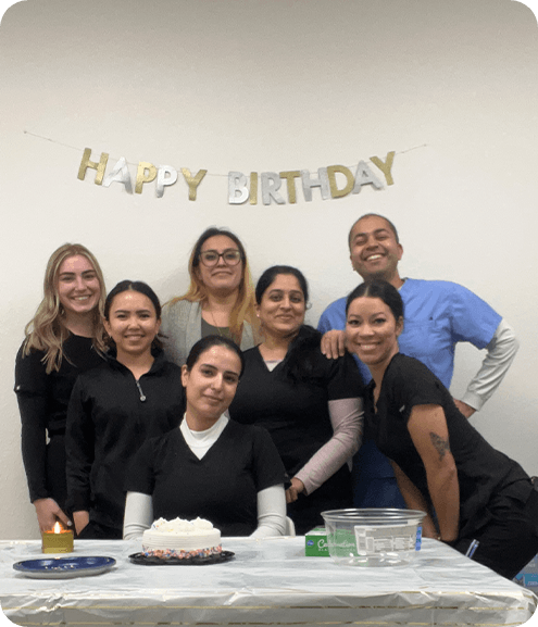 Dental team gathered around a birthday cake