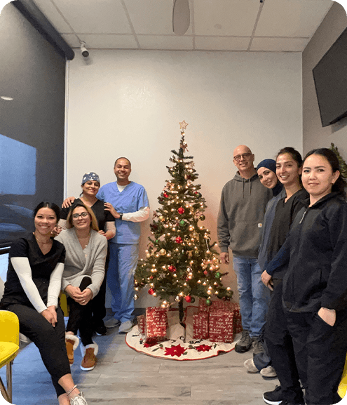 Dental team in office gathered around Christmas tree