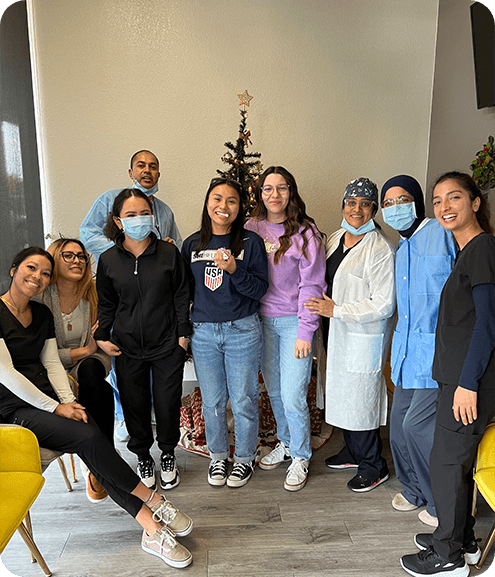 Dental team standing in office in front of Christmas tree