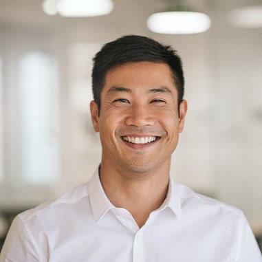 Man in white button-up shirt smiling