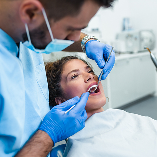 Patient having teeth cleaned by dentist