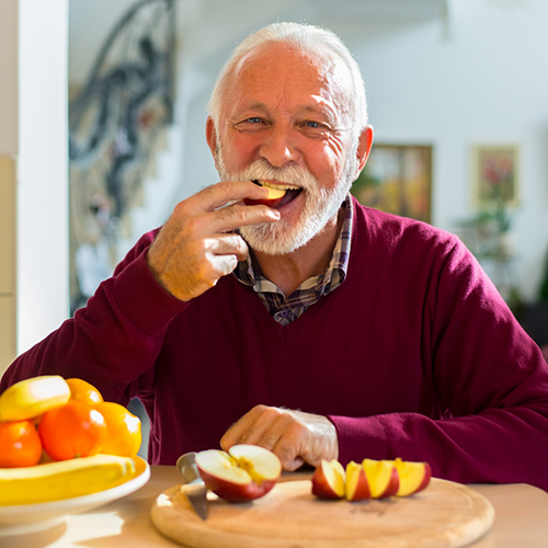 Older man eating apple slices