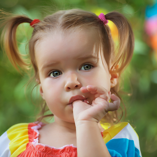 Little girl with pigtails sucking her thumb