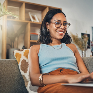 Woman smiling while working on laptop at home