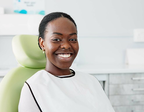Woman smiling while sitting in treatment chair