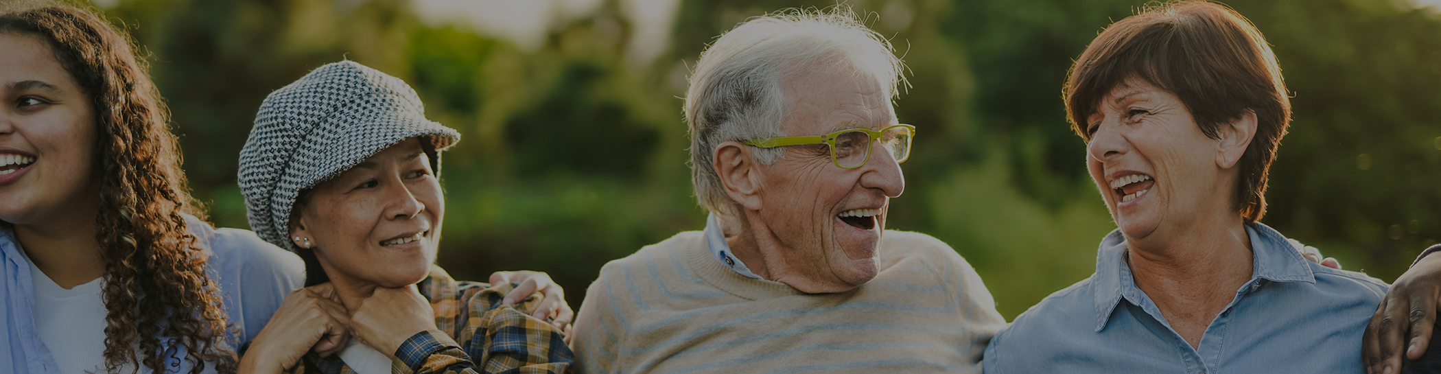 Multiple older people smiling outside