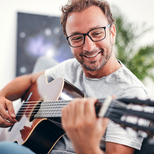 Man with glasses playing guitar
