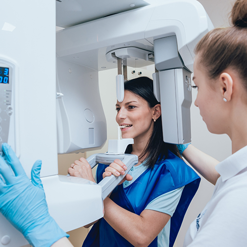 Female patient having teeth scanned with cone beam scanner