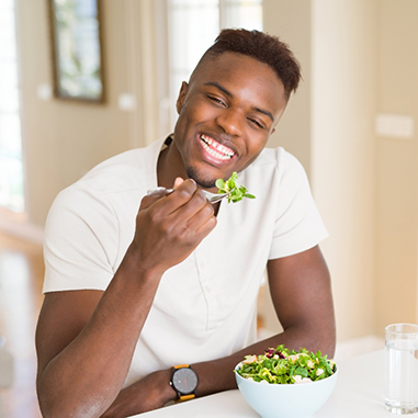 Smiling man eating a salad