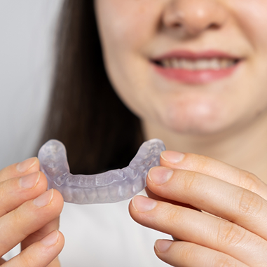 Close up of woman holding mouthguard