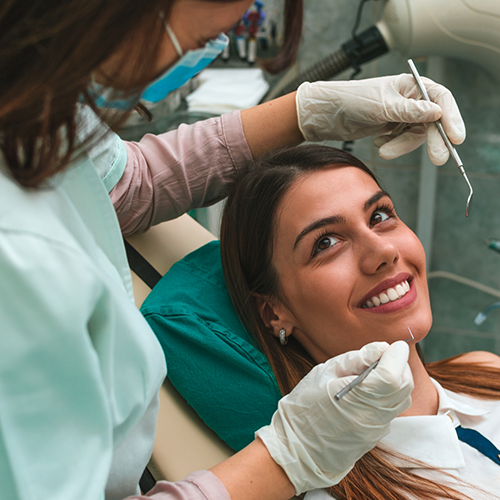 Female patient smiling up at emergency dentist in Richardson