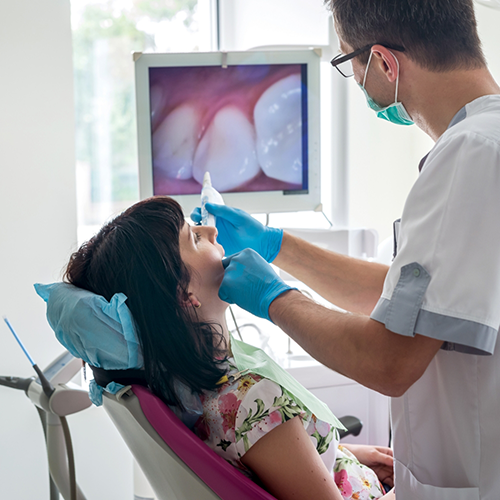 Examining patient's teeth with intraoral camera