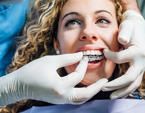 Dentist placing clear aligner on patient