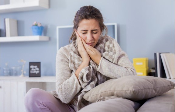 woman holding mouth in pain in Richardson