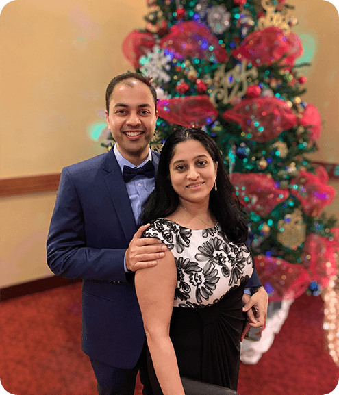 Dr. Siddharth Talsania with his wife in front of Christmas tree