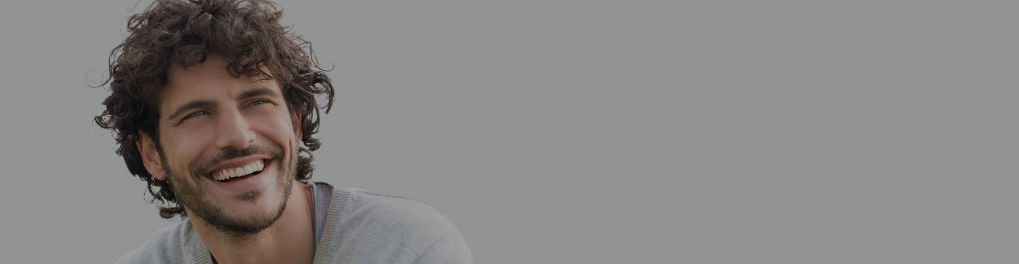 Brown haired man smiling outside