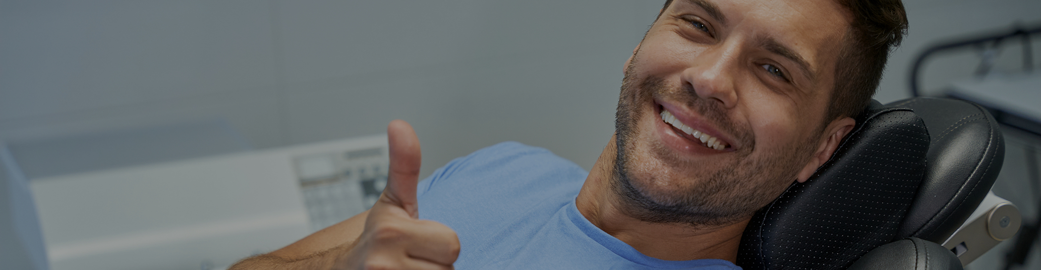 Male patient giving thumbs up in dental chair