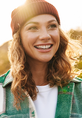 Woman in knit cap smiling outside