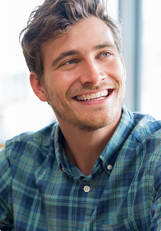 Man in blue patterned shirt smiling