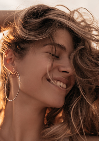Smiling woman with hoop earrings and wavy hair