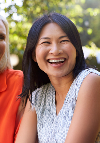 Woman smiling outside next to another woman