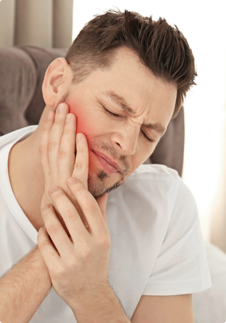 Man in white shirt rubbing jaw in pain