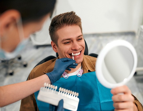 Man smiling while looking at veneer shade
