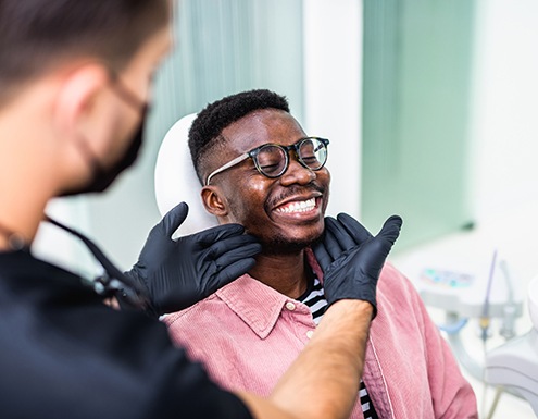 Dentist looking at patient's smile in treatment room