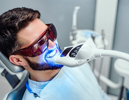 Male dental patient receiving in-office teeth whitening in Richardson, TX