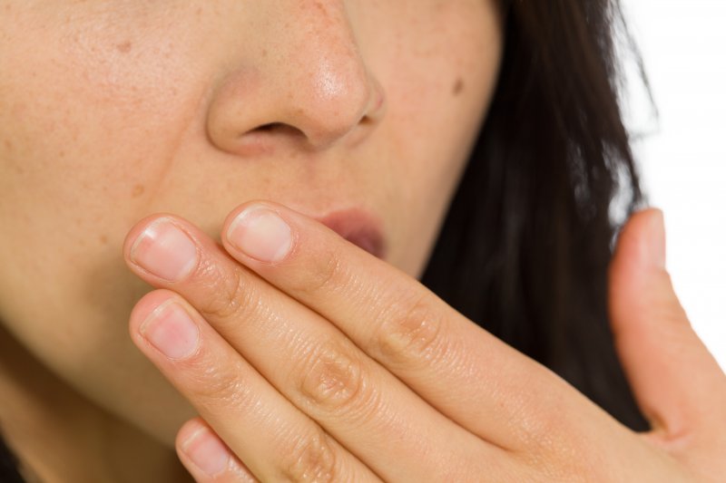 A closeup of a woman covering her mouth