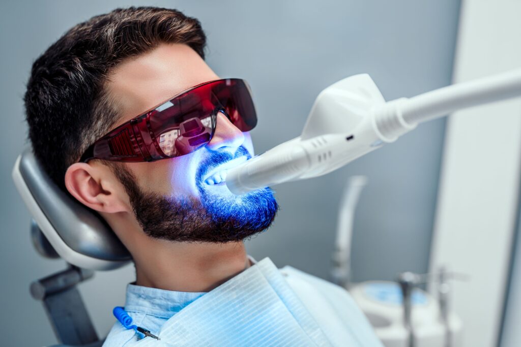 Man in dental chair having teeth professionally whitened